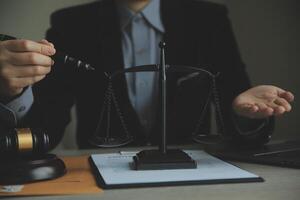 Business and lawyers discussing contract papers with brass scale on desk in office. Law, legal services, advice, justice and law concept picture with film grain effect photo