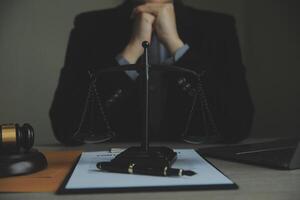 Business and lawyers discussing contract papers with brass scale on desk in office. Law, legal services, advice, justice and law concept picture with film grain effect photo