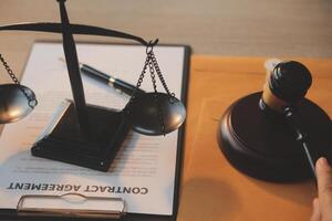 Business and lawyers discussing contract papers with brass scale on desk in office. Law, legal services, advice, justice and law concept picture with film grain effect photo