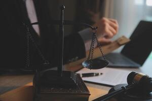 Business and lawyers discussing contract papers with brass scale on desk in office. Law, legal services, advice, justice and law concept picture with film grain effect photo