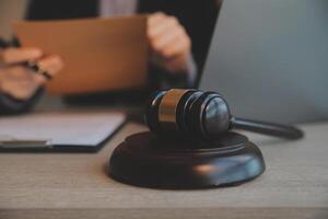 Business and lawyers discussing contract papers with brass scale on desk in office. Law, legal services, advice, justice and law concept picture with film grain effect photo