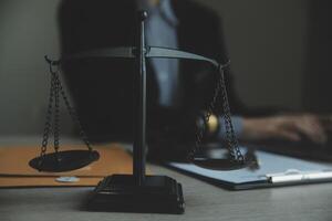 Business and lawyers discussing contract papers with brass scale on desk in office. Law, legal services, advice, justice and law concept picture with film grain effect photo