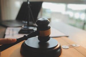 Business and lawyers discussing contract papers with brass scale on desk in office. Law, legal services, advice, justice and law concept picture with film grain effect photo