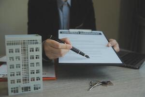 Real estate agent and customer signing contract to buy house, insurance or loan real estate.rent a house,get insurance or loan real estate or property. photo