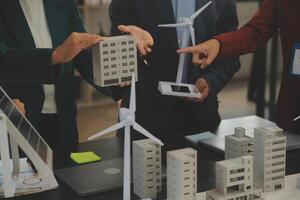 Close-up at tablet, Engineers pointing at tablet with their hands. To jointly design the use of renewable energy with wind and solar energy. Concept of using renewable energy. photo