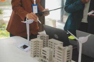 Close-up at tablet, Engineers pointing at tablet with their hands. To jointly design the use of renewable energy with wind and solar energy. Concept of using renewable energy. photo