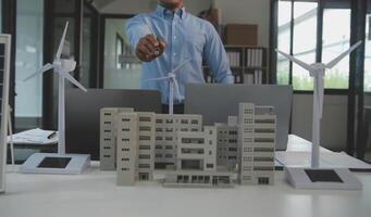 Close-up at tablet, Engineers pointing at tablet with their hands. To jointly design the use of renewable energy with wind and solar energy. Concept of using renewable energy. photo