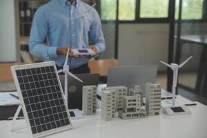 de cerca a tableta, ingenieros señalando a tableta con su manos. a conjuntamente diseño el utilizar de renovable energía con viento y solar energía. concepto de utilizando renovable energía. foto