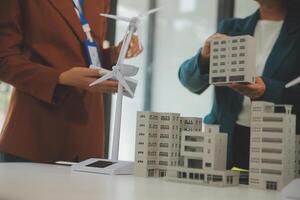 Close-up at tablet, Engineers pointing at tablet with their hands. To jointly design the use of renewable energy with wind and solar energy. Concept of using renewable energy. photo