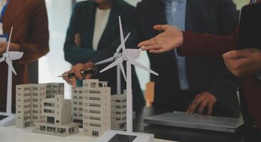 Close-up at tablet, Engineers pointing at tablet with their hands. To jointly design the use of renewable energy with wind and solar energy. Concept of using renewable energy. photo