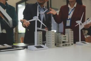 Close-up at tablet, Engineers pointing at tablet with their hands. To jointly design the use of renewable energy with wind and solar energy. Concept of using renewable energy. photo