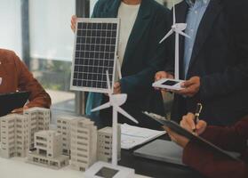 de cerca a tableta, ingenieros señalando a tableta con su manos. a conjuntamente diseño el utilizar de renovable energía con viento y solar energía. concepto de utilizando renovable energía. foto