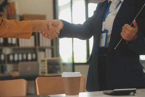 Real estate broker agent and customer shaking hands after signing contract documents for realty purchase, Bank employees congratulate, Concept mortgage loan approval. photo