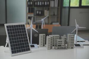 de cerca a tableta, ingenieros señalando a tableta con su manos. a conjuntamente diseño el utilizar de renovable energía con viento y solar energía. concepto de utilizando renovable energía. foto