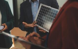 de cerca a tableta, ingenieros señalando a tableta con su manos. a conjuntamente diseño el utilizar de renovable energía con viento y solar energía. concepto de utilizando renovable energía. foto