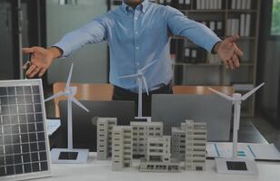 Close-up at tablet, Engineers pointing at tablet with their hands. To jointly design the use of renewable energy with wind and solar energy. Concept of using renewable energy. photo