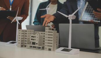 Close-up at tablet, Engineers pointing at tablet with their hands. To jointly design the use of renewable energy with wind and solar energy. Concept of using renewable energy. photo