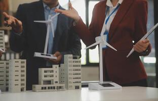 Close-up at tablet, Engineers pointing at tablet with their hands. To jointly design the use of renewable energy with wind and solar energy. Concept of using renewable energy. photo