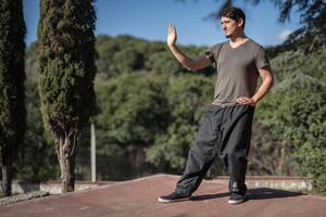 Lateral wide shot of a man in a Chi Kung posture photo