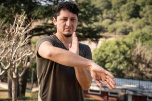 Middle-Aged Man Practices Kung Fu, a Chinese Martial Art, Outdoors. photo