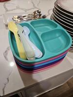 kids plates and utensils served in a party near other cutlery on the kitchen island beside the served food photo