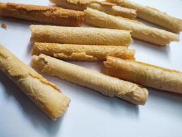 Kue semprong or Asian egg roll. This is a traditional Indonesian wafer or kuih snack isolated on a white background photo