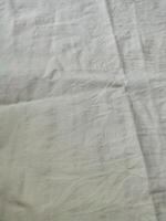 Fabric backdrop White linen canvas crumpled natural cotton fabric Natural handmade linen top view background Organic Eco textiles White Fabric linen texture photo