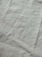 Fabric backdrop White linen canvas crumpled natural cotton fabric Natural handmade linen top view background Organic Eco textiles White Fabric linen texture photo