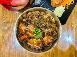 Japanese food called Buta Don or Gyu Don or Beef Rice Bowl or Pork Rice Bowl served with miso soup and fried egg roll. photo