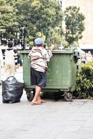 Woman collects garbage, cardboard and plastic to take it for processing and get money for food. Jakarta, Indonesia, May 1, 2024 photo