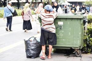 Woman collects garbage, cardboard and plastic to take it for processing and get money for food. Jakarta, Indonesia, May 1, 2024 photo