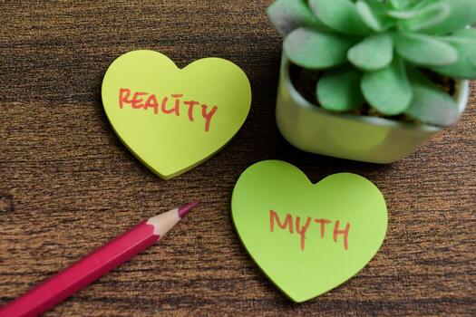 Concept of Reality or Myth write on sticky notes isolated on Wooden Table. photo