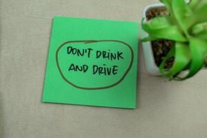 Concept of Don't Drink and Drive write on sticky notes isolated on Wooden Table. photo