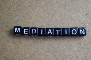 Concept of Mediation written on wooden blocks. Cross processed image on Wooden Background photo