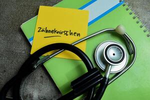 Concept of Learning language - German. Zahneknirschen it means Grinding teeth written on sticky notes. German language isolated on Wooden Table. photo