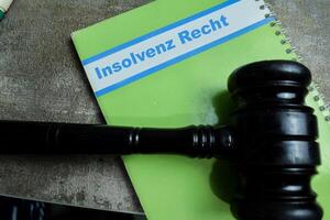 Concept of Learning language - German. Insolvenz Recht it means Insolvency law written on book. German language isolated on Wooden Table. isolated on Wooden Table. photo