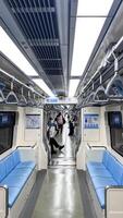 LRT Jakarta train interior seating area, departure station, bright train interior, empty seats. Passenger seatless train with blue seats photo