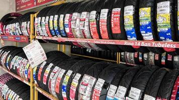 Car tires on rack in auto store, motorcycle transport concept. Bekasi, Indonesia, April 22, 2024 photo