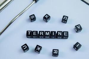 Concept of Termine written on wooden blocks. Cross processed image on Wooden Background photo