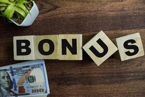 Concept of The wooden Cubes with the word Bonus on wooden background. photo