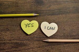 Concept of Yes, I Can write on sticky notes isolated on Wooden Table. photo