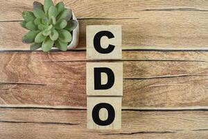 Concept of The wooden Cubes with the word CDO - Collateralized Debt Obligations on wooden background. photo
