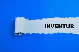 Concept of Inventur in Language Germany Text written in torn paper. photo