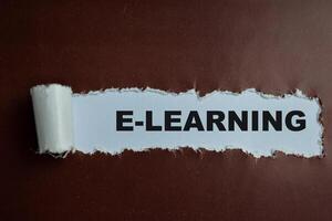 Concept of E-Learning Text written in torn paper. photo