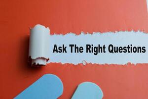 Concept of Ask the Right Questions Text written in torn paper. photo