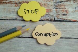 Concept of Stop Corruption write on sticky notes isolated on Wooden Table. photo