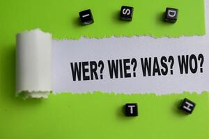 Concept of Wer Wie Was Wo Text written in torn paper. photo