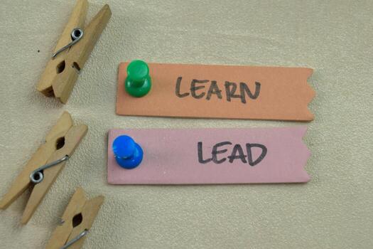 Concept of Learn and Lead write on sticky notes isolated on Wooden Table. photo