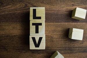 Concept of The wooden Cubes with the word LTV - Life Time Value on wooden background. photo