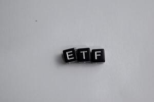 Concept of ETF written on wooden blocks. Cross processed image on Wooden Background photo